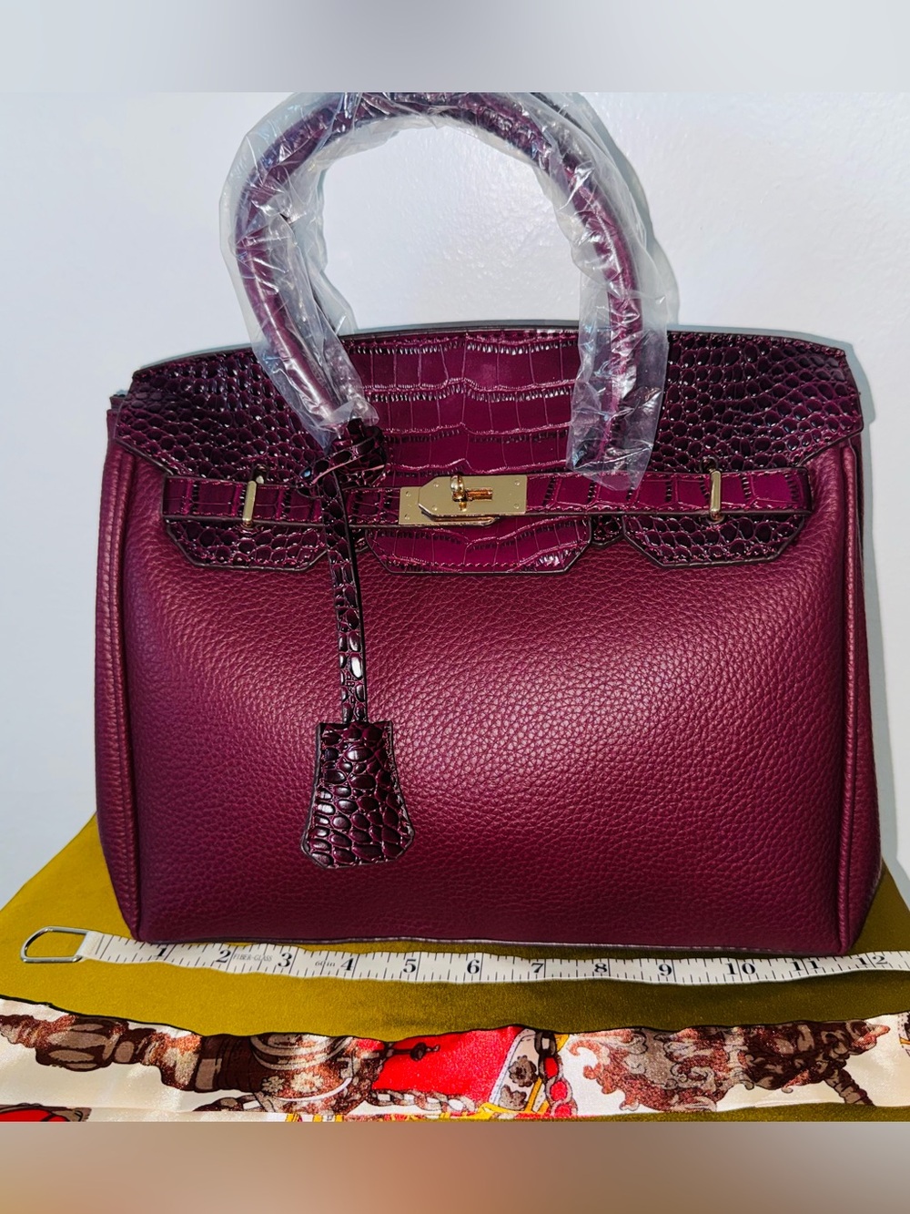 Burgundy structured top handle bag with gold hardware